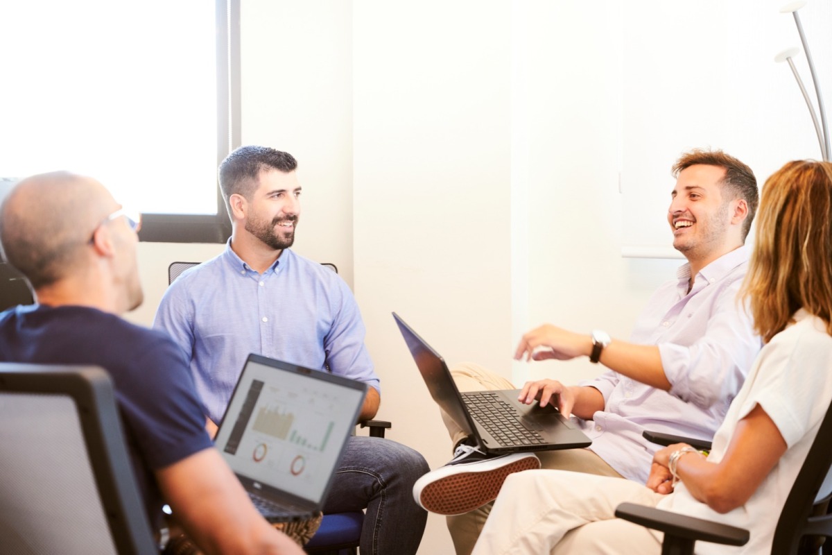 a group of employees sit together and are talking