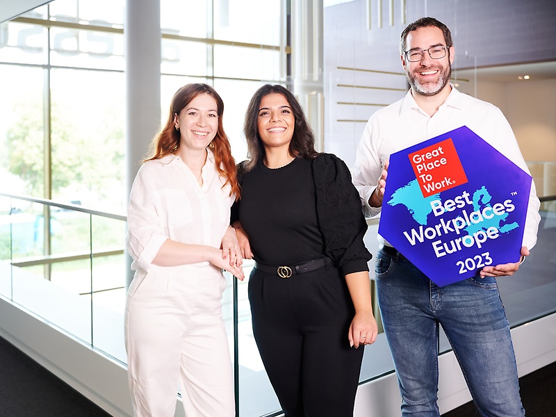 People holding the "Best Workplace" Trophy