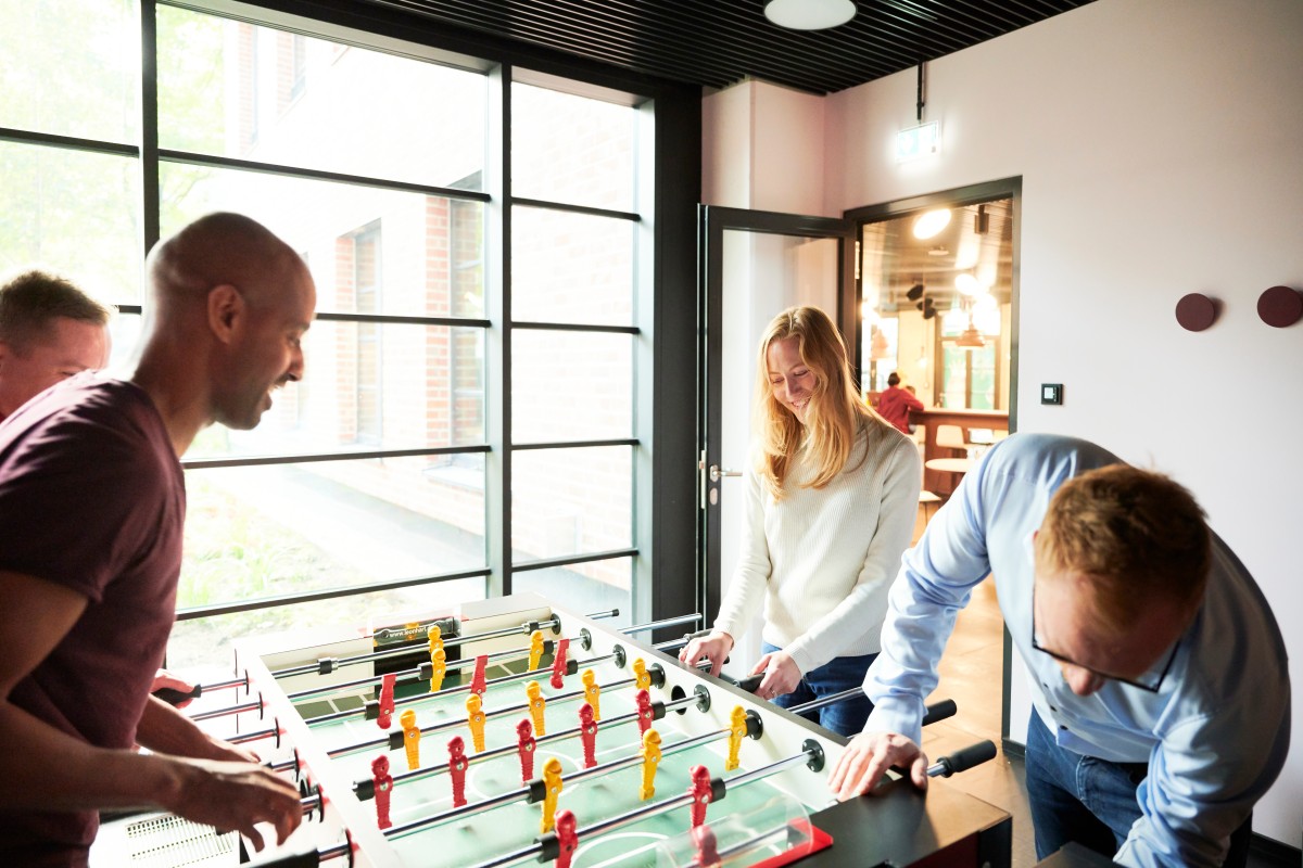 a group o fpeople are playing table soccer